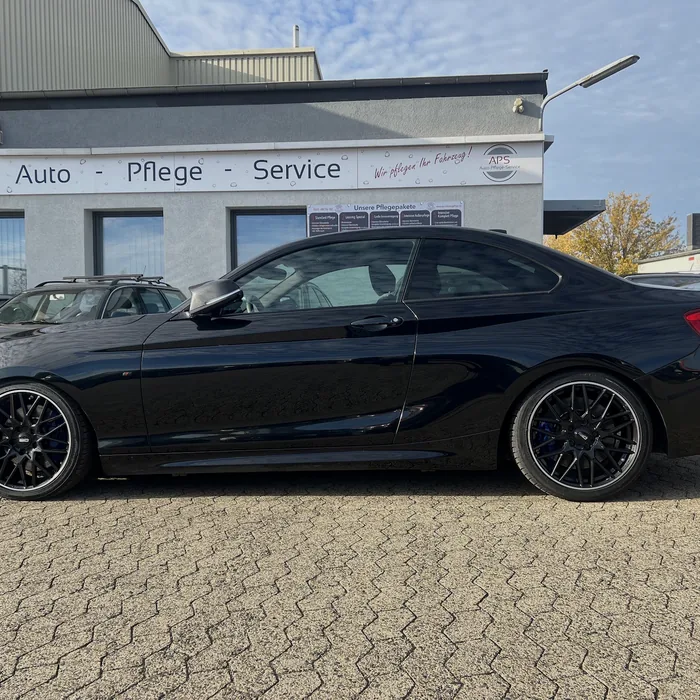Schwarzes BMW M2 Coupé auf dem Hof der Werkstatt
